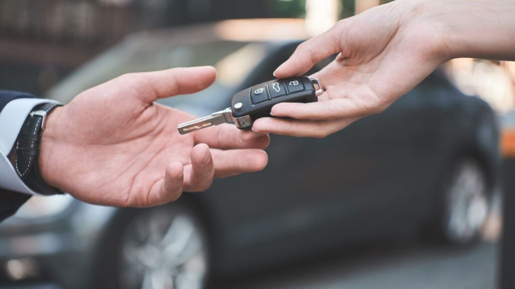 Locksmith handing off fixed key to client after car key replacement service in Walkertown, NC