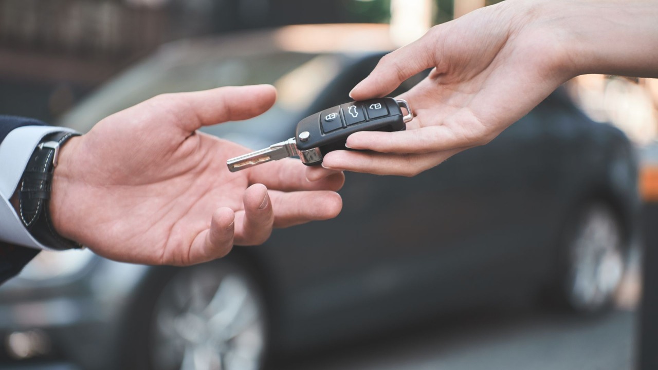 Locksmith handing off fixed key to client after car key replacement service in Walkertown, NC